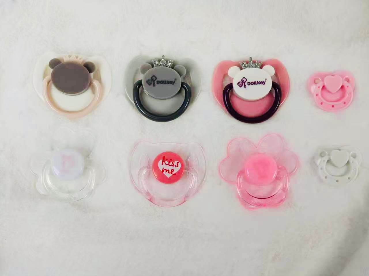 Choose any four pacifiers from the baby doll